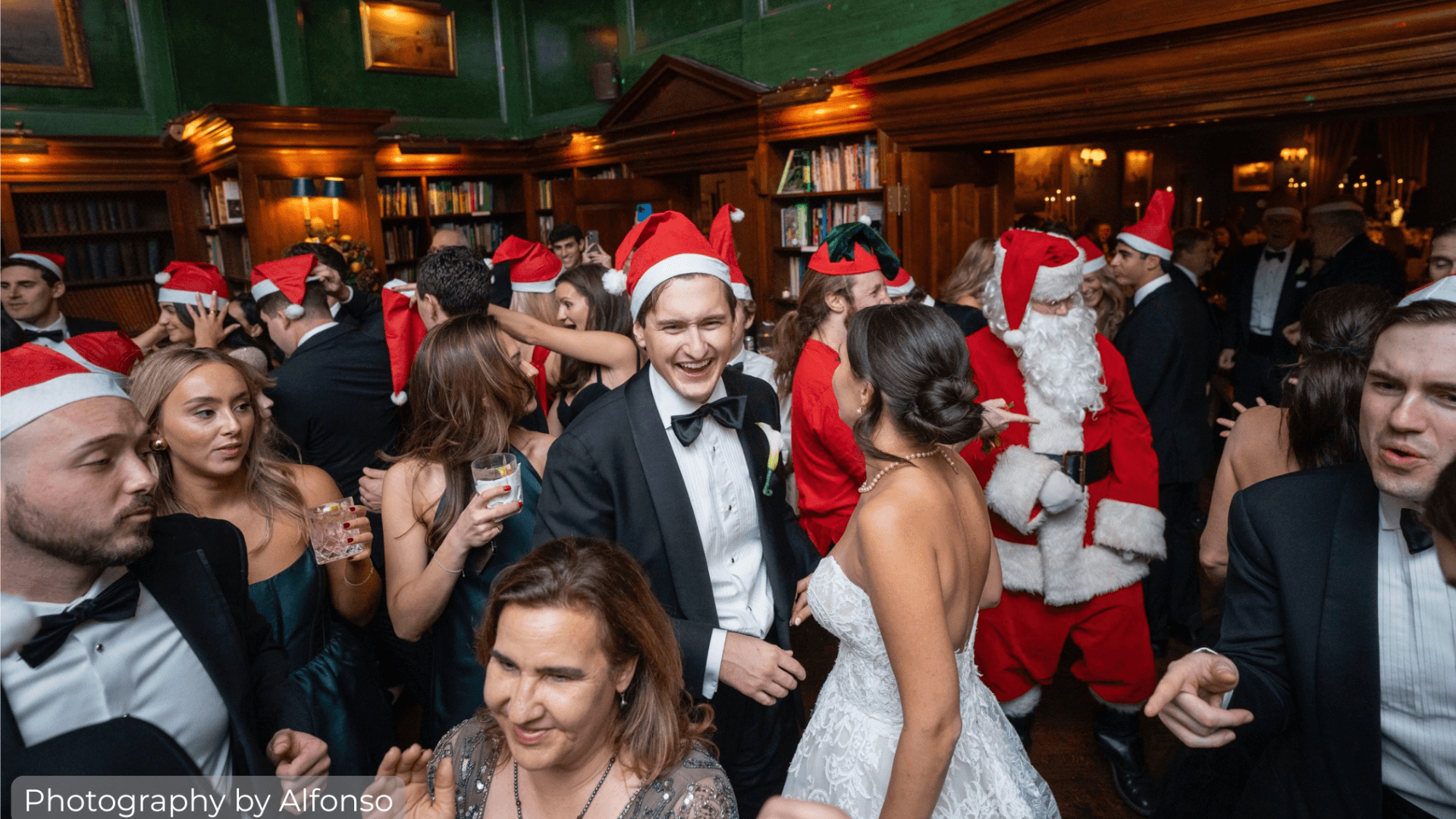 Bride and Groom with guests dancing in santa hats