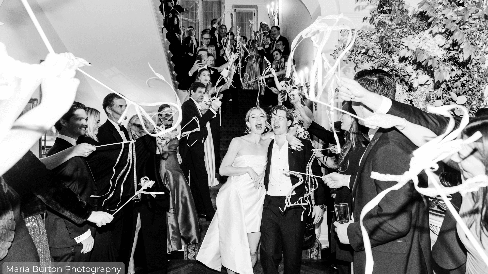 Grand exit for bride and groom surrounded by guests